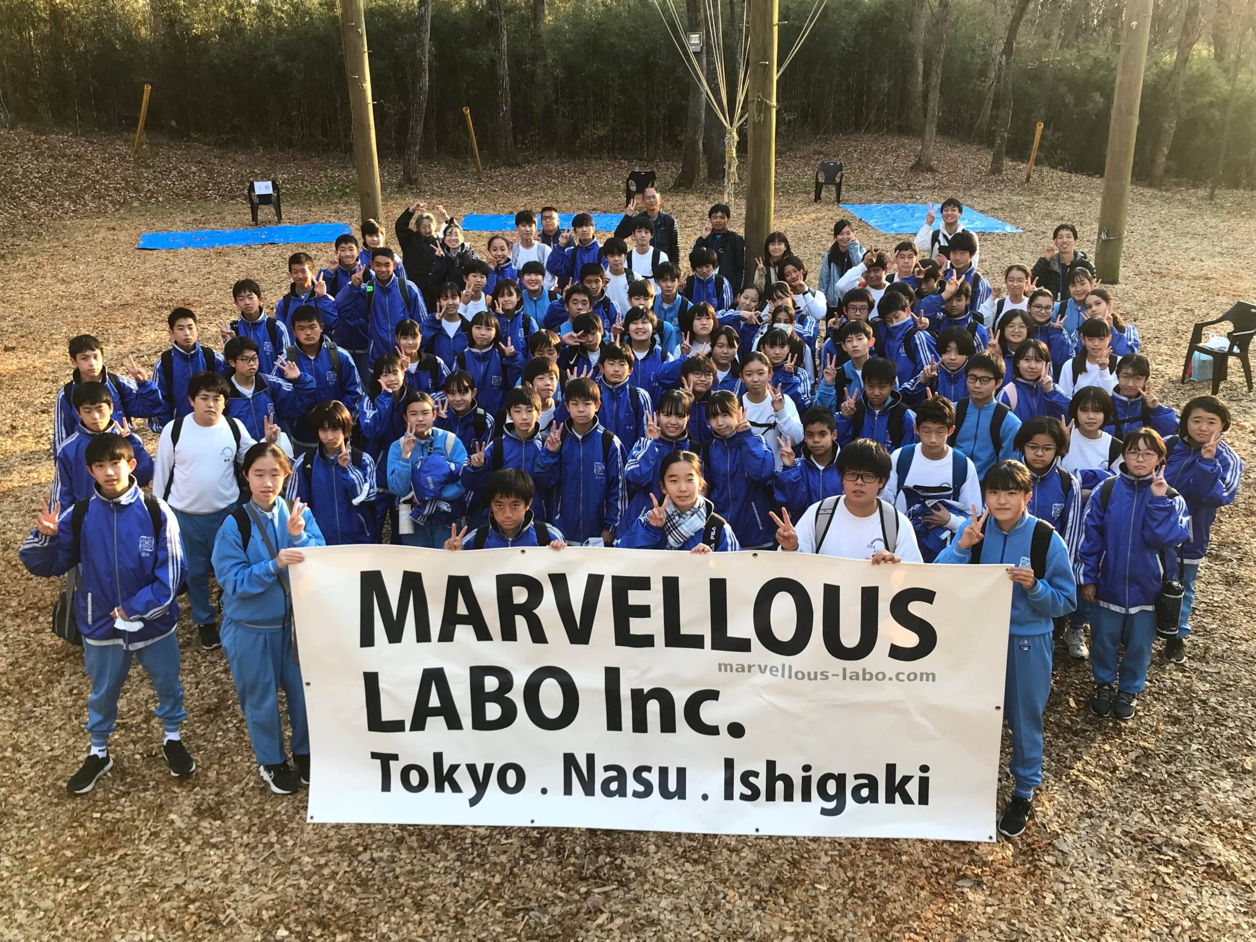 「MARVELLOUS LABO」の大きな旗を持って整列する参加者たち（太田市立旭中学校）