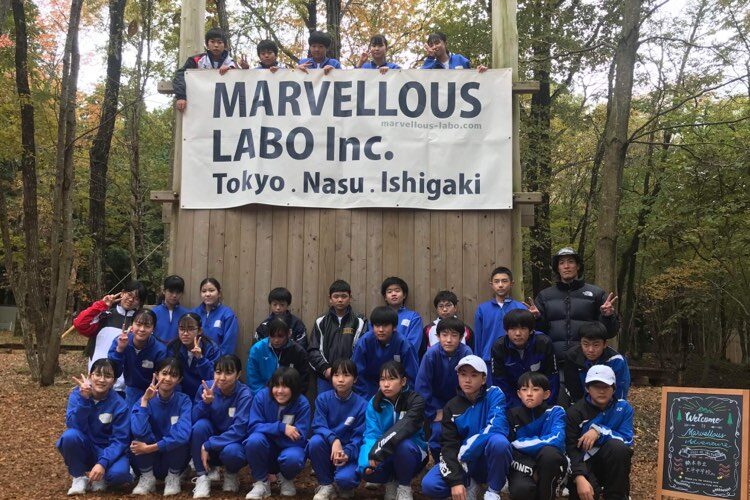 「MARVELLOUS LABO」の旗を取り付けた木製の壁の前に整列する参加者たち（栃木市立大平中学校01）