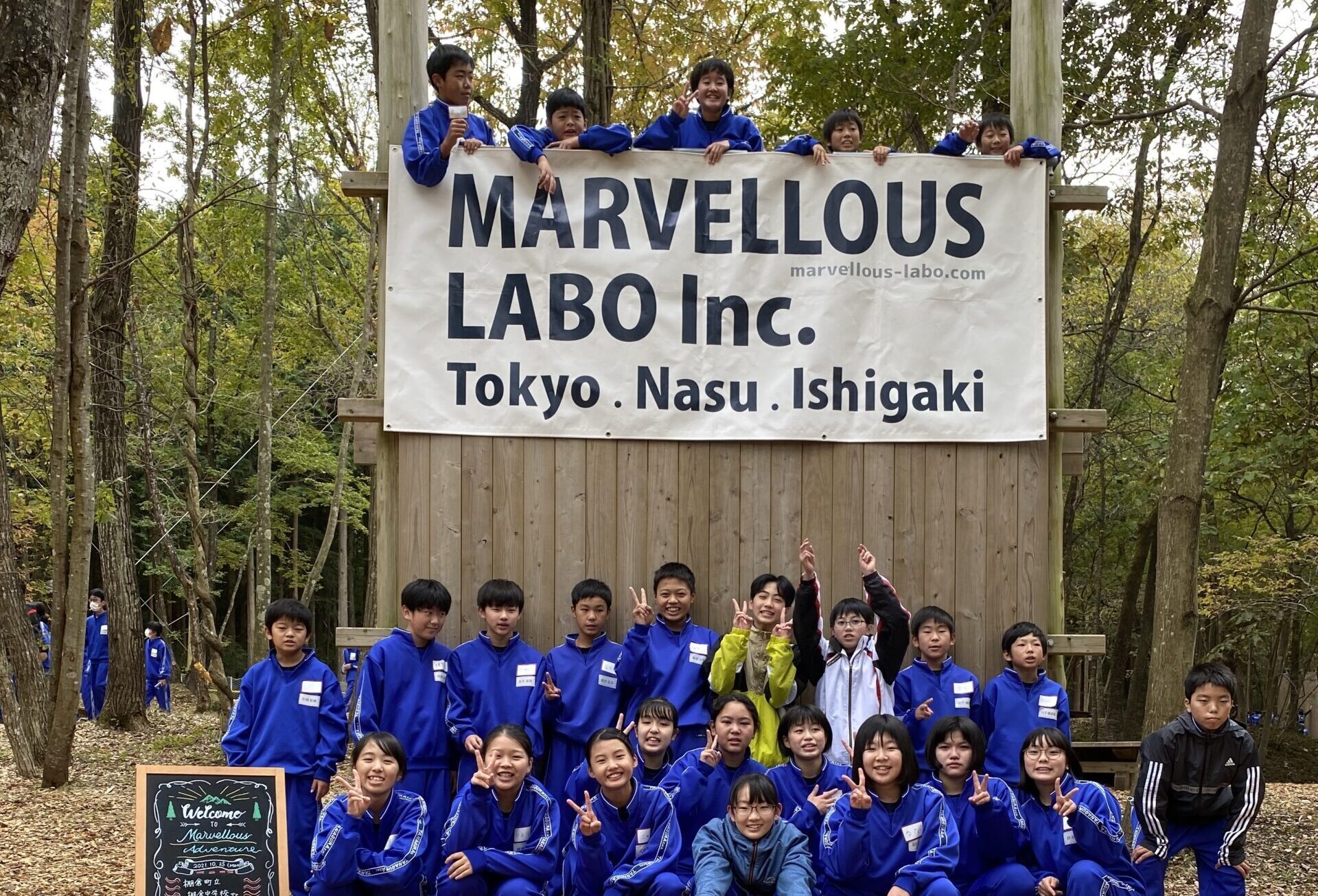 「MARVELLOUS LABO」の旗を取り付けた木製の壁の前に整列する参加者たち（棚倉町立棚倉中学校）
